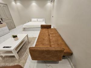 a living room with a couch and a bed at استديو انيق وراقي in Riyadh