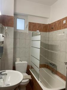 ein Badezimmer mit einem Waschbecken, einem WC und einer Badewanne in der Unterkunft Varvitsiotis Studios in Kalavryta