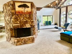 a living room with a large stone fireplace at Faithful Oak 4 acre ranch mountain 3BR +Loft King in Escondido