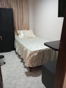 a small bed with white sheets in a room at Habitación # 1 Moderna y Cómoda in Bello