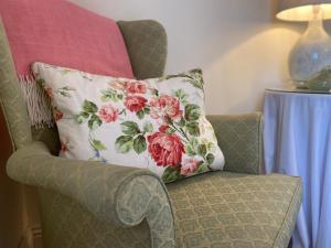 a pillow sitting on a chair next to a table at Lower Farm Cottage in Beaminster