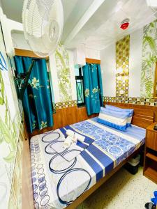 een slaapkamer met een bed met blauwe en witte lakens bij United Co-Operate Guest House (7/F) in Hong Kong