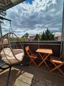 eine Veranda mit einer Schaukel, 2 Stühlen und einem Tisch in der Unterkunft Koala Apartment mit 500 Mbit's WLAN und Balkon in Leipzig