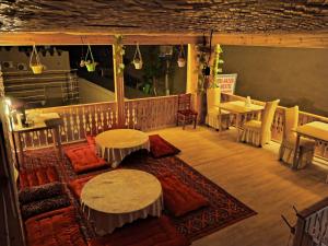 ein Restaurant mit Tischen und Stühlen auf einem Balkon in der Unterkunft Rasul-Nazar in Xiva