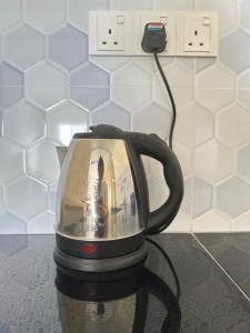 un mixeur noir posé sur un comptoir avec un chargeur dans l'établissement B10-6@Pd marina resort, à Port Dickson