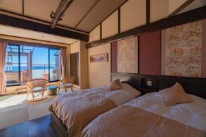 河津町Isoaruki no Yuyado Ushiogumo -6 years or older-的一间带床的卧室，可欣赏海景