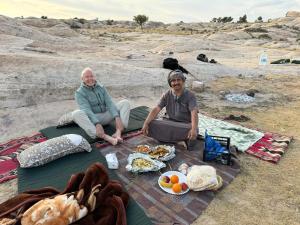 two people sitting on a blanket with a picnic at Dana Tower Hotel in Dana