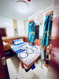 1 dormitorio con 1 cama con cortinas azules en Kyoto Guest House (15/F) en Hong Kong