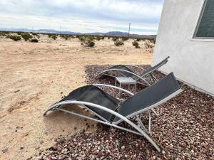 a couple of chairs sitting outside of a building at Modern & Private Desert Home w/ ez access and near Joshua Tree in Twentynine Palms