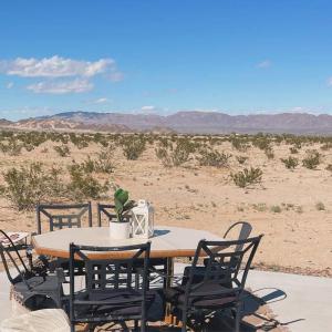 a wooden table with chairs and a table with a plant on it at Modern & Private Desert Home w/ ez access and near Joshua Tree in Twentynine Palms