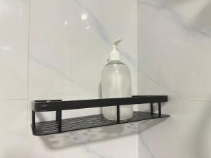 une bouteille de savon sur une étagère au mur dans l'établissement B10-6@Pd marina resort, à Port Dickson 21 autres photos