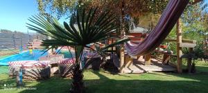 een hangmat en stoelen naast een zwembad bij Cabañas Casas Alto Madero in Las Cruces