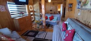 ein Wohnzimmer mit 2 blauen Sofas und einem Tisch in der Unterkunft Cabañas Casas Alto Madero in Las Cruces