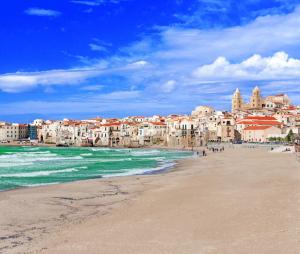a view of a beach with buildings and the ocean at Cortile Maggiore Home in Cefalù