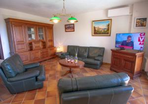 a living room with leather furniture and a tv at Villa Ma Rosa, 160m2, 4ch, Piscine et Jardin in Mandelieu-la-Napoule