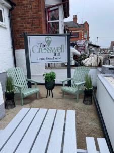 two green benches sitting in front of a sign at The Cresswell Inn in Skegness