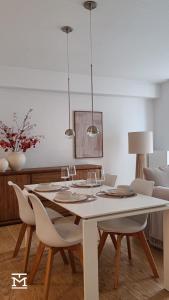 een eetkamer met een witte tafel en stoelen bij Suite Maritim - Zijdelings zeezicht op 50m van strand en zee in Knokke-Heist