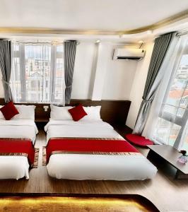2 camas en una habitación con 2 ventanas en Le Tuan Minh Hotel, en Da Lat