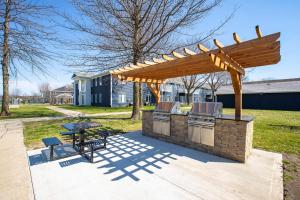 an outdoor kitchen with a wooden pergola at Welcoming 4BR near ISU in Ames