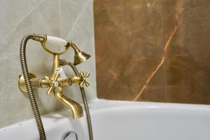 a bath tub with a faucet and a shower at CORESI MALL Large 2 camere, sleeps 6 in Braşov +21 photos