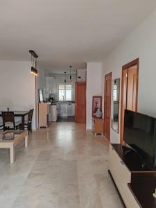 een woonkamer met een televisie en een eetkamer bij Seaview Apartment with Great Amenities & Facilities in Benalmádena