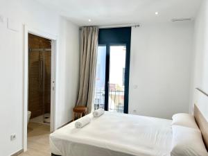 una camera da letto con un letto bianco e un balcone di Moderno apartamento con gran terraza a Roses