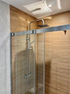 e bagno con doccia e parete in legno. di Moderno apartamento con gran terraza a Roses