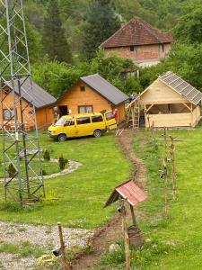 una furgoneta amarilla estacionada en un patio al lado de las casas en Bungalovi Mihajlo & Miloš, en Tjentište