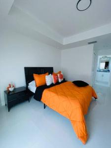 a bedroom with a bed with an orange blanket at White house 2 in Lehigh Acres