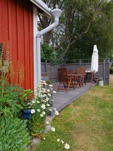 a patio with two chairs and a table and umbrella at Abbis lillstuga in Norra Vallgrund