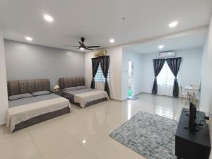 a bedroom with two beds and a ceiling fan at 232 Permai Duyung Family Gathering in Seremban