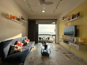 een woonkamer met een bank en een televisie bij 1-6 Pax BBQ + Hot Pot - Relaxing Seaview in Port Dickson