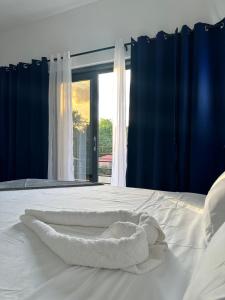 - une serviette blanche sur un lit avec fenêtre dans l'établissement White Signature Suite, à Kingston