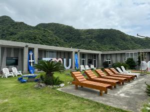a row of wooden benches in front of a building at 樂見海 in Green Island