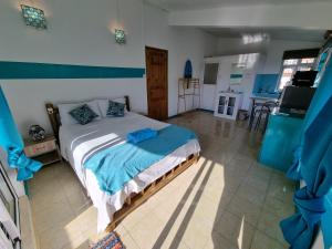 - une chambre avec un lit dans une pièce avec une cuisine dans l'établissement Surf House, à La Gaulette