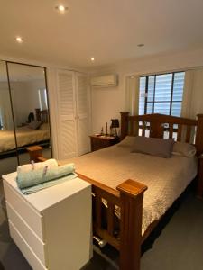 a bedroom with a large bed and a mirror at Everingham Views in Rockhampton