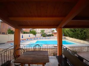 eine Terrasse mit einem Tisch und einem Pool in der Unterkunft Piccola Locanda S'Ausentu in 