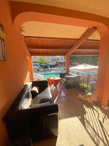 - un salon avec un canapé et une piscine dans l'établissement Piccola Locanda S'Ausentu, à Uri