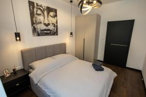 a bedroom with a bed and a painting on the wall at Apartament Prestige in Nowy Sącz