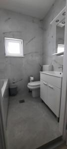 a bathroom with a sink and a toilet and a window at Apartments Marijana in Zavalatica