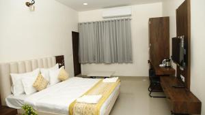 a hotel room with a bed and a television at Goroomgo Hotel The Nirmala Palace Ayodhya-Near Ram Mandir in Ayodhya