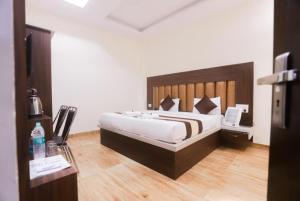 - une chambre avec un grand lit dans l'établissement Goroomgo Hotel The Nirmala Palace Ayodhya-Near Ram Mandir, à Ayodhya