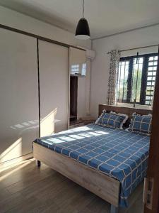 ein Schlafzimmer mit einem großen Bett mit einer blauen Decke in der Unterkunft Oceanic Villa in Flic-en-Flac