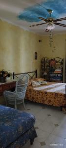 a bedroom with two beds and a desk and a fan at La casa di Mariù in Furnari