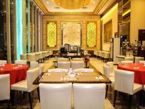 una sala da pranzo con tavoli e sedie bianche di Batam City Hotel a Nagoya