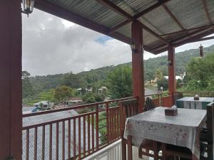 a balcony with a table and a view of a river at moni mahalika in Kelimutu