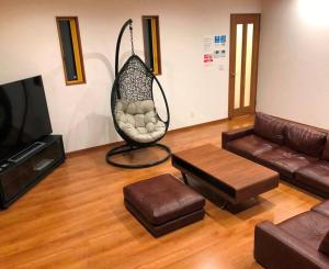 a living room with a couch and a swing at 森の空気を感じる宿泊 露天風呂 Wi-Fi 最大20名様 in Shima
