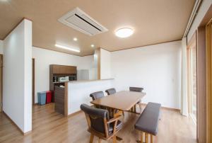 a kitchen and dining room with a table and chairs at 森の空気を感じる宿泊 露天風呂 Wi-Fi 最大20名様 in Shima