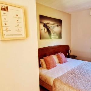a bedroom with a bed and a picture of a bridge at Tempo Hôtel in Millau