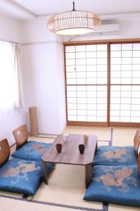 a living room with a table and a couch at 名古屋の部屋駅近で人工温泉のお風呂が楽しめます in Yadachō